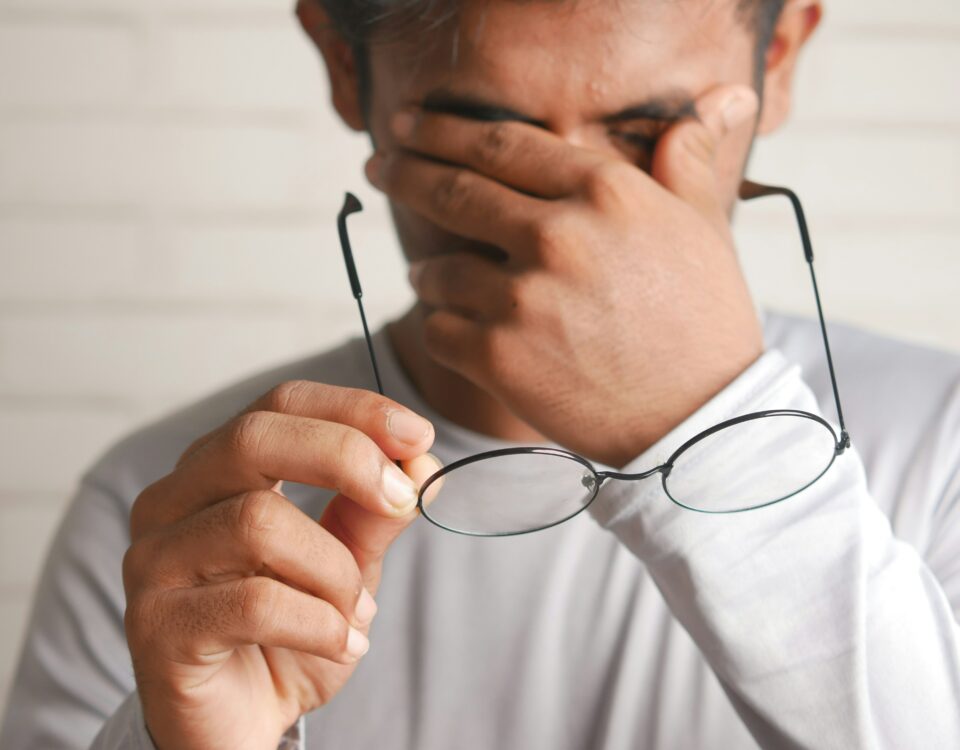 Das Bild zeigt einen Mann, der sich erschöpft die Augen reibt und eine Brille in der Hand hält, was auf gesundheitliche Beschwerden oder Müdigkeit hinweist. Die elektronische Arbeitsunfähigkeitsbescheinigung (eAU) ermöglicht es, Krankmeldungen schnell und effizient digital an den Arbeitgeber und die Krankenkasse zu übermitteln. Dies erleichtert den Prozess der Krankmeldung und reduziert den administrativen Aufwand.