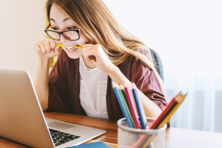 Eine Person sitzt vor einem Laptop und beißt gestresst auf einen Bleistift, was auf Schwierigkeiten oder Herausforderungen hinweist. Dieser Ausdruck der Anspannung könnte mit der komplexen Berechnung des Progressionsvorbehalts zusammenhängen, die oft als herausfordernd und frustrierend empfunden wird. Der Progressionsvorbehalt führt dazu, dass bestimmte steuerfreie Einkünfte die Steuerlast erhöhen, was bei vielen Menschen für Unsicherheit und Stress sorgen kann.