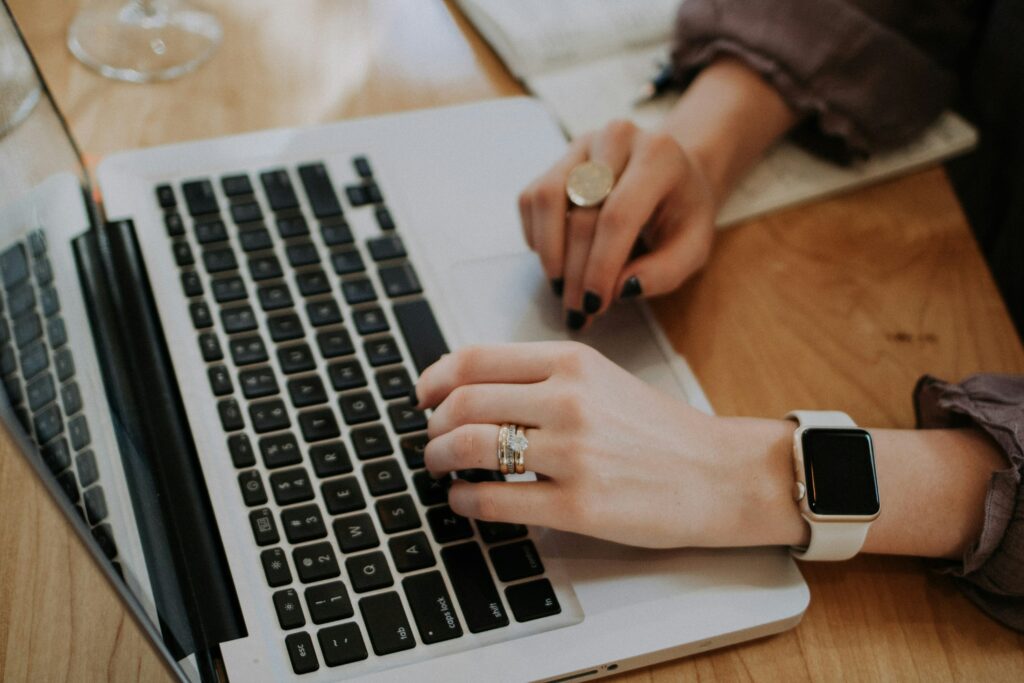 Eine arbeitende Person an einem Laptop. Die Szene vermittelt einen professionellen Kontext, in dem Bürotätigkeiten ausgeführt werden. In Verbindung mit einem Beschäftigungsverbot verweist das Bild auf die administrative Bearbeitung von Aufgaben wie der Lohn- und Gehaltsabrechnung im Rahmen der Arbeitsregelungen.